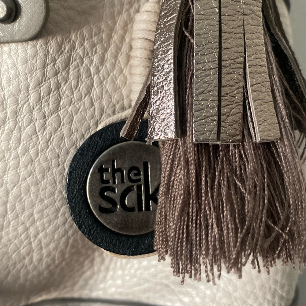 The Sak,cream,gray,silver with a brown braided strap. Cute purse.
